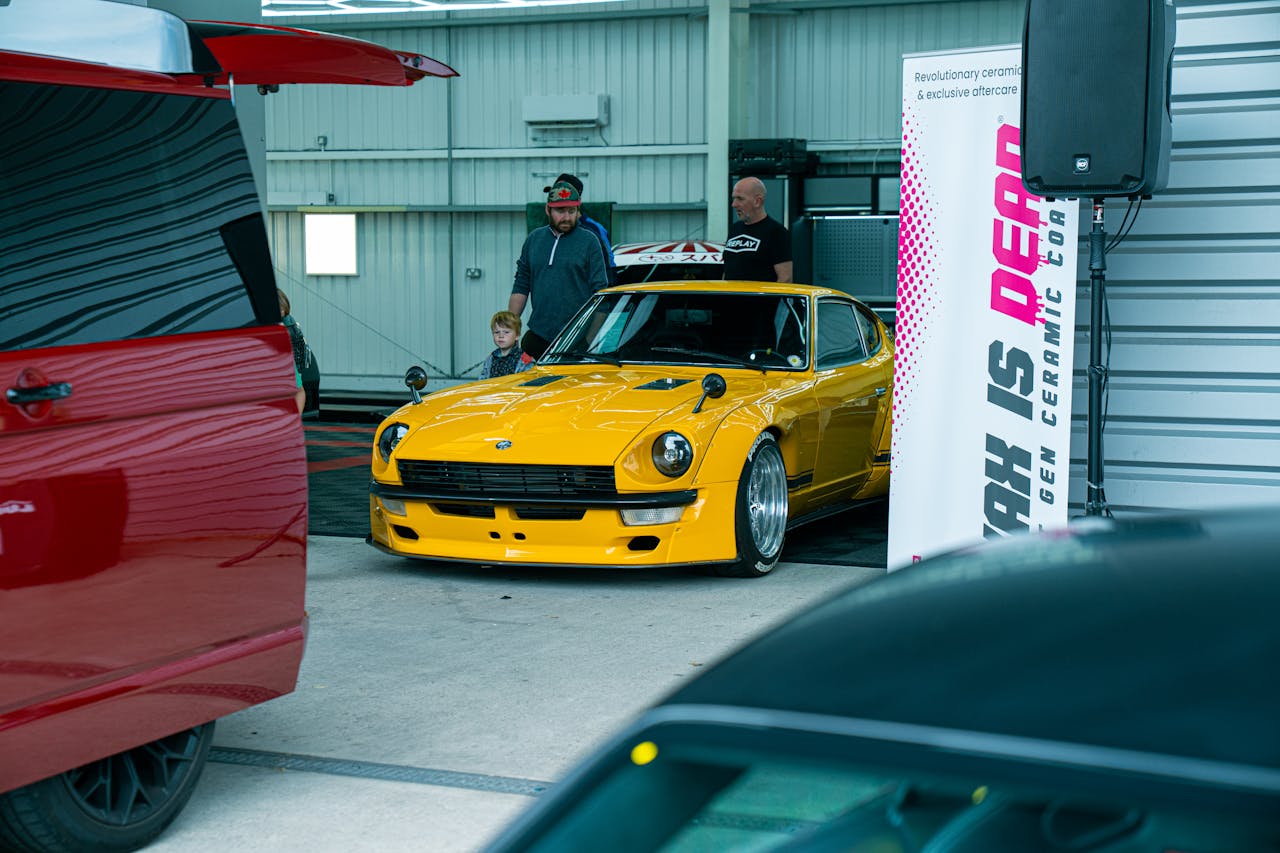Vibrant yellow car showcased indoors at a Southampton auto event with spectators.